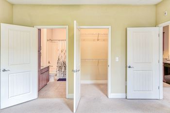 two open doors leading into a bathroom and large walk-in closet